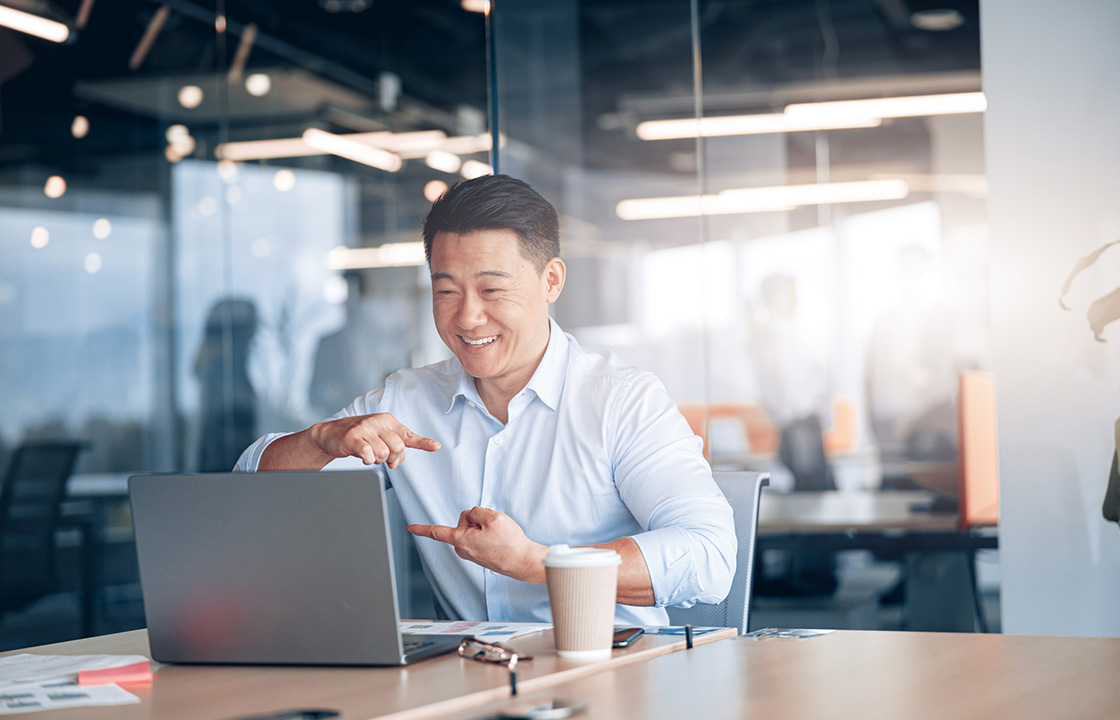 man using sign language in front of a laptop in an office