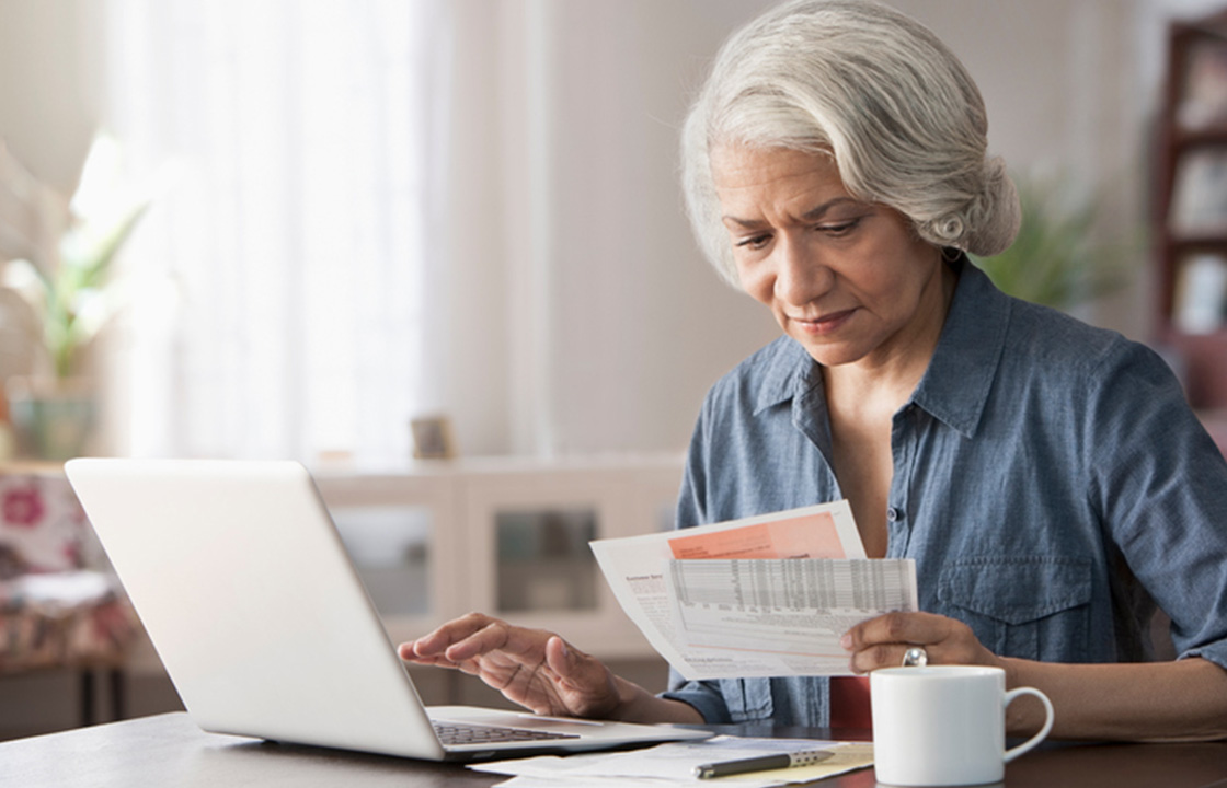 senior lady at computer looking over documents